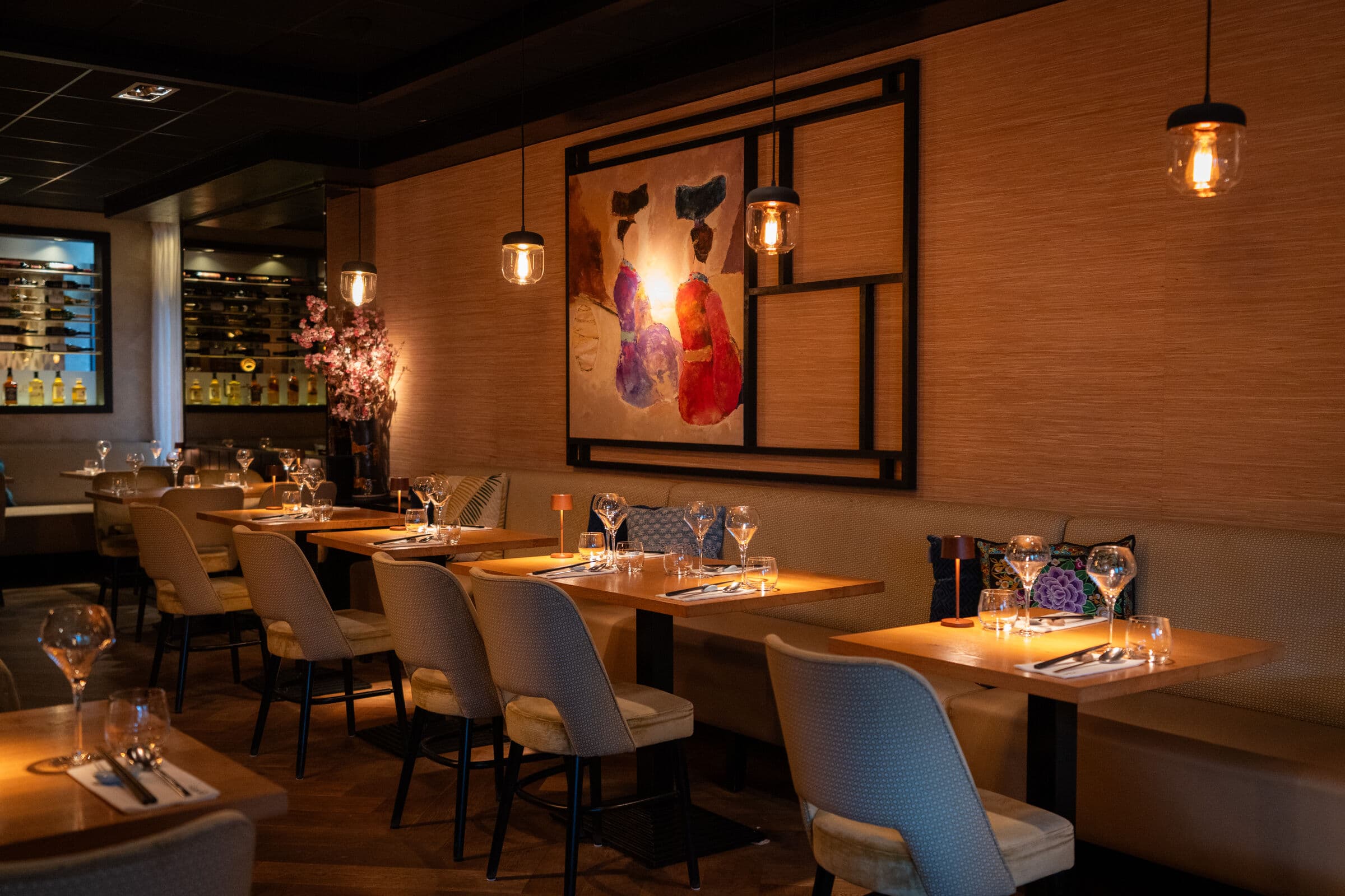 De zaal van Restaurant Lan Tin met gedekte tafels en hanglampen